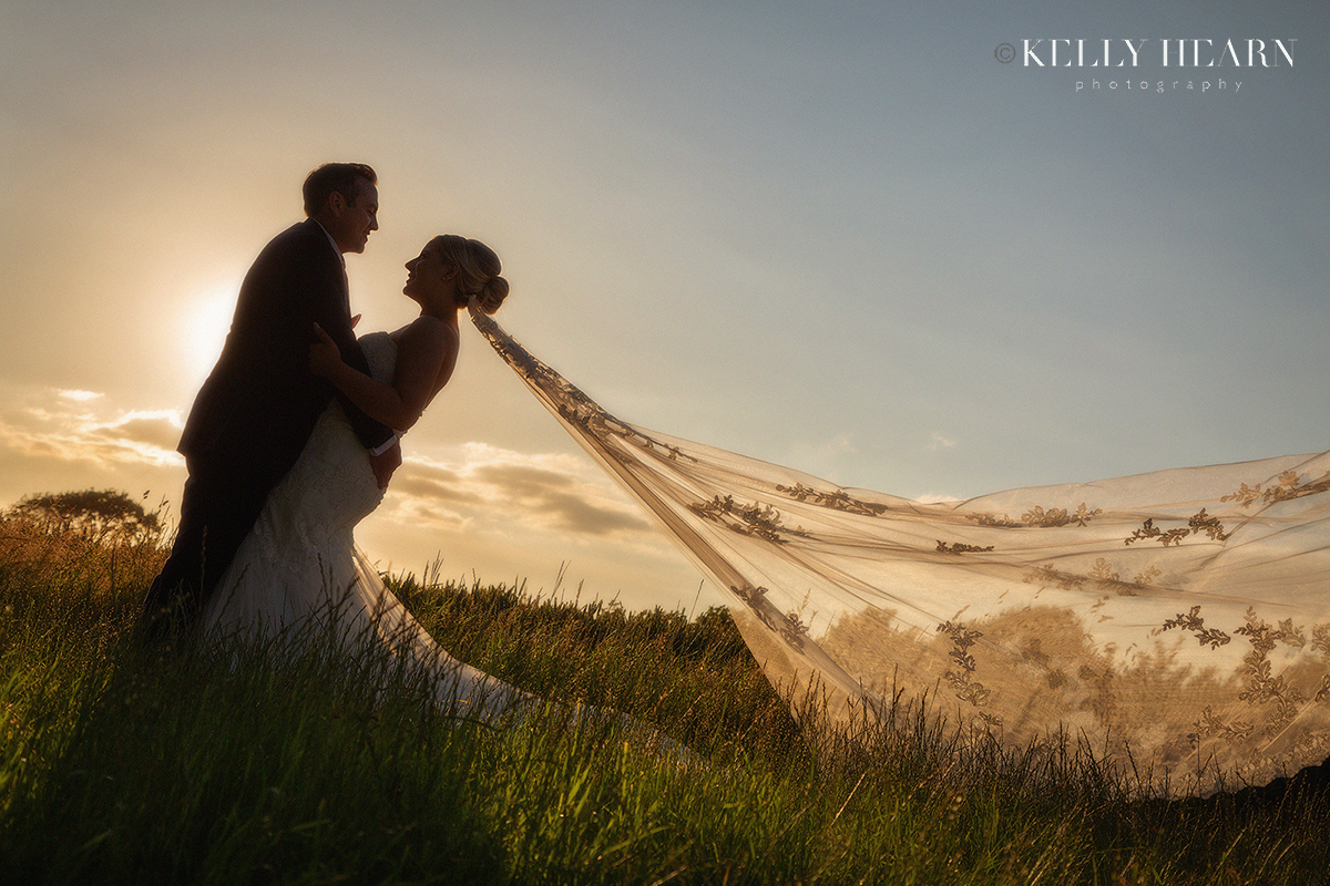FRE_bride-groom-sunset-field-veil.jpg#asset:3575