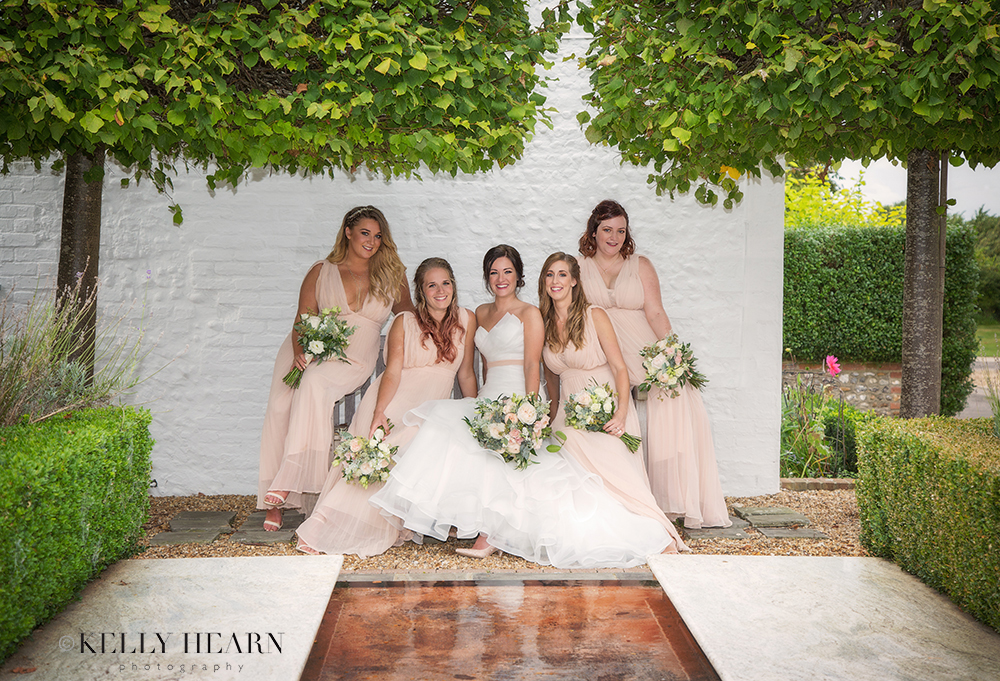 HAR_bride-bridesmaids-on-bench-garden.jpg#asset:1815